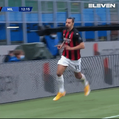 a soccer player with the number 11 on his shorts is running on the field