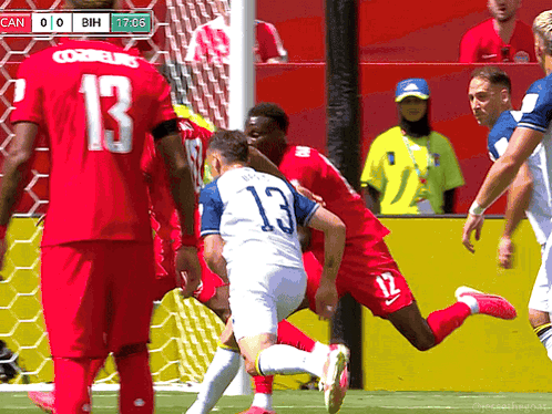 A Soccer Player With The Number 13 On His Jersey Is Being Tackled By Another Player GIF