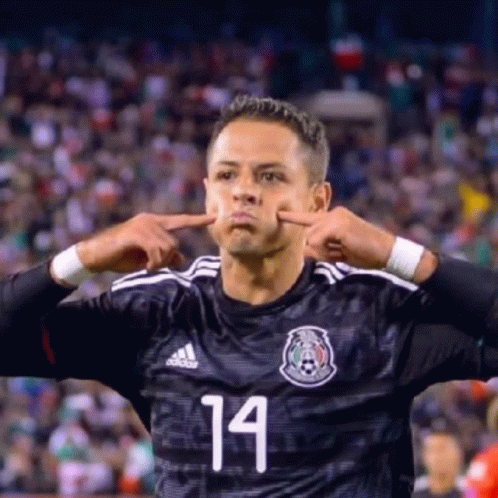 a soccer player with the number 14 on his jersey making a funny face