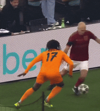 a soccer player with the number 17 on his jersey kicks the ball