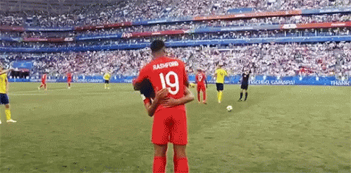 A Soccer Player With The Number 19 On His Jersey Is Hugging Another Soccer Player . GIF
