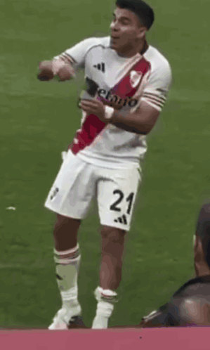 A Soccer Player With The Number 21 On His Shorts Is Standing On The Field GIF