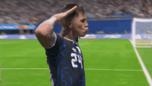 A Soccer Player With The Number 24 On His Jersey Salutes The Crowd GIF