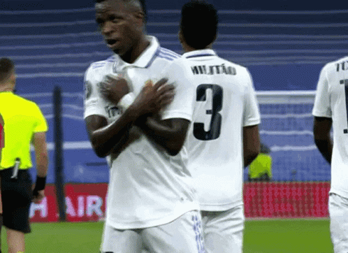 a soccer player with the number 3 on his jersey is talking to another player