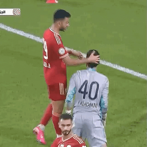A Soccer Player With The Number 40 On His Back Is Being Touched By Another Player . GIF