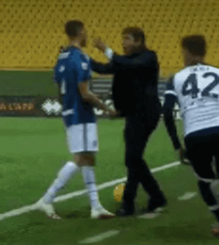 a soccer player with the number 42 on his jersey talks to another player