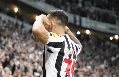 A Soccer Player With The Number 70 On His Jersey Stands In Front Of A Crowd GIF
