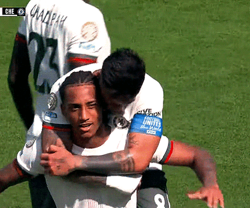 A Soccer Player With The Number 8 On His Armband Is Hugging Another Player GIF