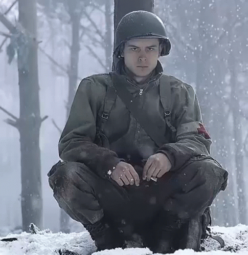 A Soldier In A Helmet Sits In The Snow GIF