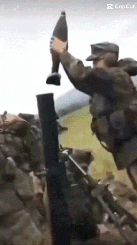 A Soldier Is Holding A Bottle In His Hand While Another Soldier Holds A Gun GIF