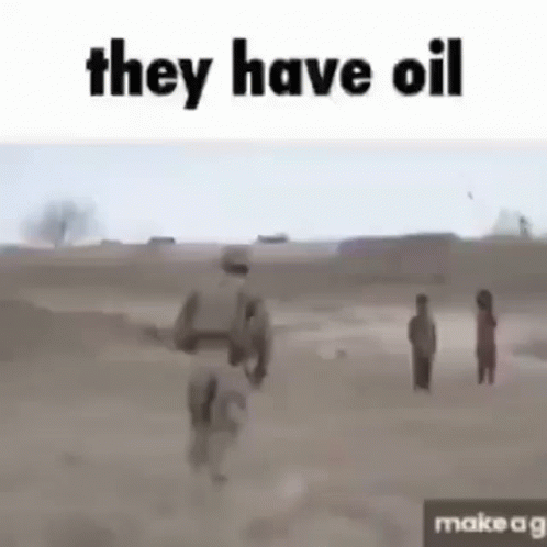 a soldier is walking through a dirt field with a group of children .