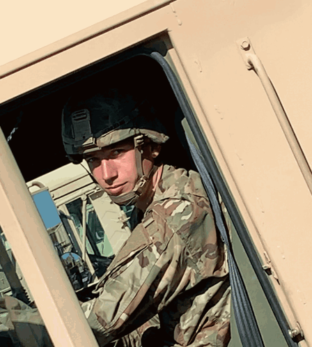 A Soldier Wearing A Helmet Looks Out Of A Window GIF