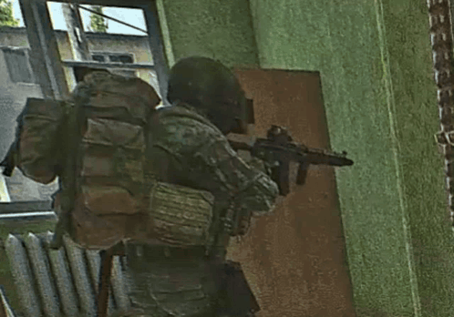 A Soldier With A Backpack Is Holding A Gun In A Room GIF