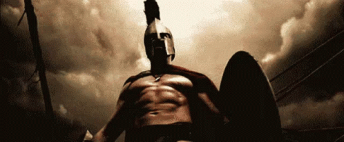 A Spartan Warrior Is Holding A Shield And Wearing A Helmet GIF