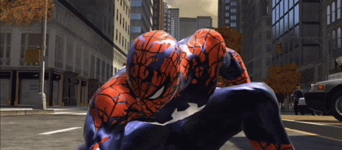 A Spider Man Is Kneeling Down On The Street GIF