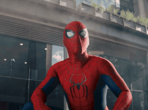 A Spider Man Standing In Front Of A Building GIF