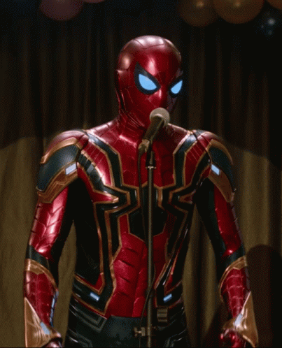 A Spiderman Is Singing Into A Microphone With Balloons In The Background GIF