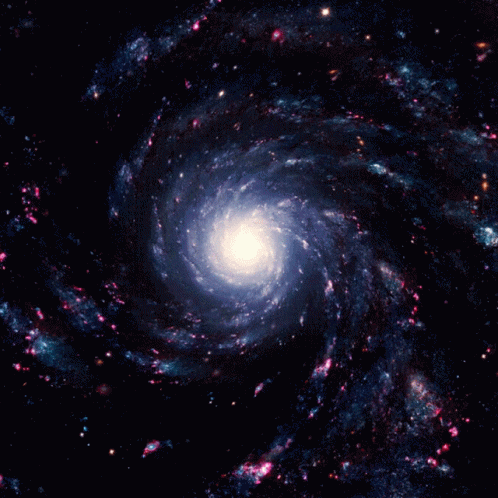 A Spiral Galaxy With A White Center Surrounded By Blue And Pink Stars GIF