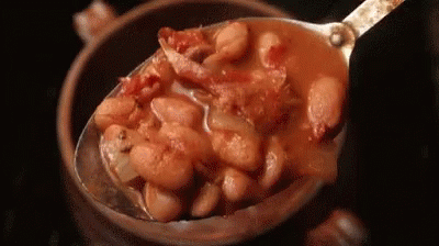 A Spoon Is Scooping Beans Out Of A Bowl . GIF