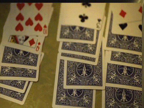 A Stack Of Blue And White Playing Cards With Hearts Diamonds And Spades On Them GIF