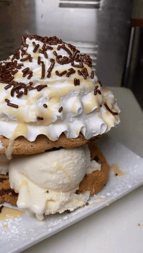 A Stack Of Cookies With Ice Cream And Whipped Cream GIF