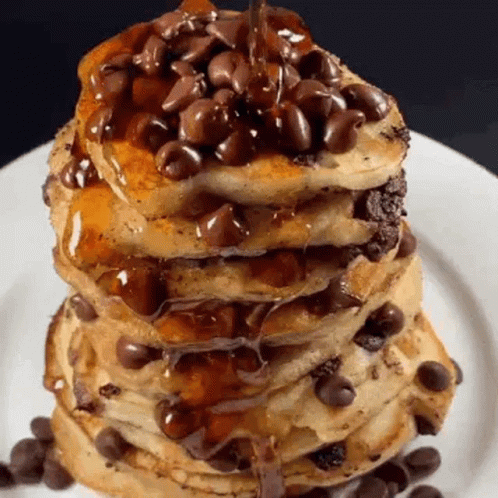A Stack Of Pancakes With Chocolate Chips On Top On A White Plate . GIF