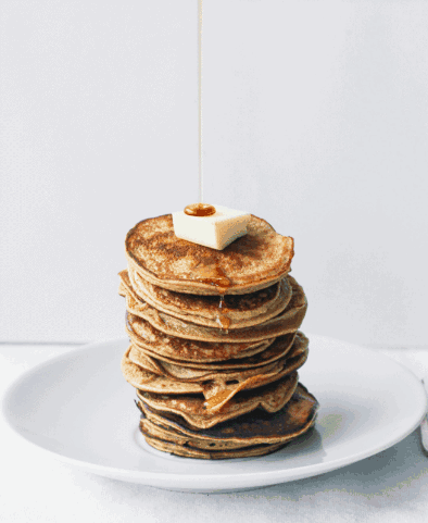 A Stack Of Pancakes With Syrup Being Poured On Top Of Them GIF