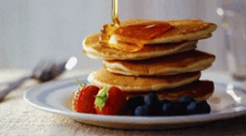 A Stack Of Pancakes With Syrup Being Poured Over Them GIF