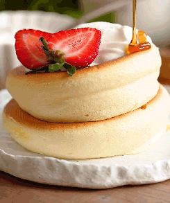 A Stack Of Pancakes With Whipped Cream And Strawberries GIF