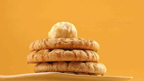 A Stack Of Peanut Butter Cookies On A White Plate With A Tong GIF