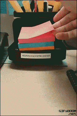 a stack of sticky notes sits on a desk with a gifsboom.net logo in the corner