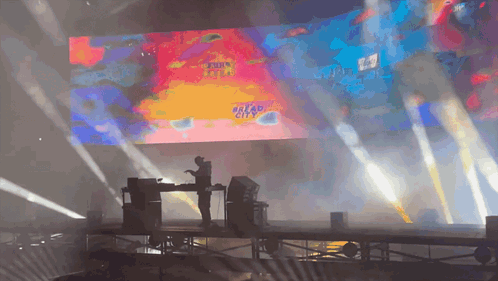 A Stage With A Large Screen Behind It That Says Dread City GIF