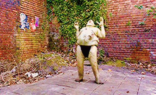 A Statue In Front Of A Brick Wall That Says ' A ' On It GIF