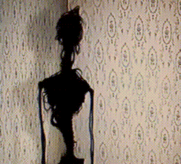 A Statue Is Silhouetted Against A Wall With A Pattern Of Circles GIF