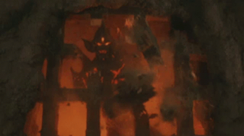 a statue of a demon is standing in a dark cave .