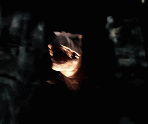 A Statue Of A Dinosaur With Its Mouth Wide Open GIF