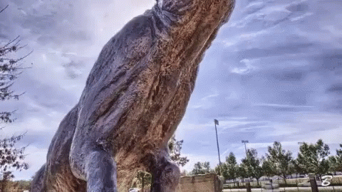 A Statue Of A Dinosaur With The Letter B On The Bottom Left GIF