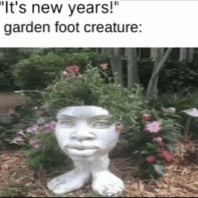 A Statue Of A Garden Foot Creature With Flowers On Its Head GIF