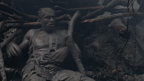 A Statue Of A Man Covered In Mud With The Word Jesus On His Chest GIF