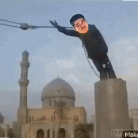 A Statue Of A Man Is Hanging From A Rope In Front Of A Mosque GIF