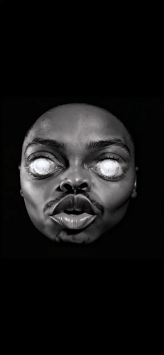 A Statue Of A Man 'S Face With Glowing Eyes In The Dark GIF