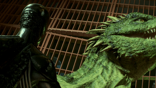 A Statue Of A Man Standing Next To A Large Green Monster GIF