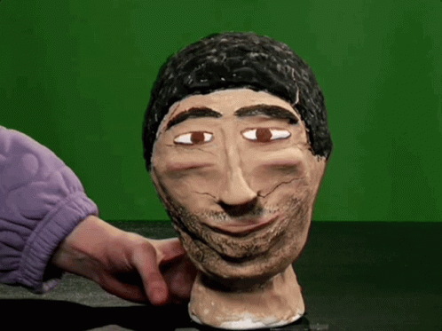 A Statue Of A Man With A Beard Is Being Touched By Someone In A Purple Sweater GIF