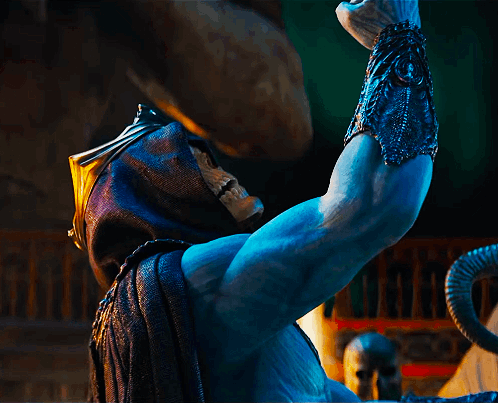 A Statue Of A Man With A Skull On His Face Is Holding Something In His Hand GIF