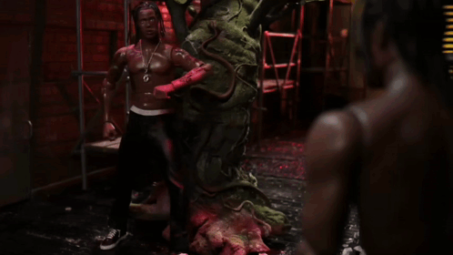 A Statue Of A Man With Dreadlocks And A Necklace That Says ' G ' On It GIF