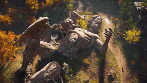 A Statue Of A Man With Wings Is Laying On Top Of A Rock . GIF