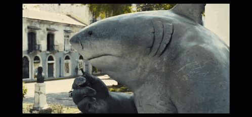 A Statue Of A Shark In Front Of A Building That Says ' A ' On It GIF