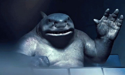 A Statue Of A Shark Is Waving His Hand In The Dark GIF