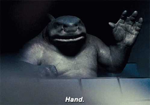 A Statue Of A Shark Waving With The Words Hand Behind It GIF