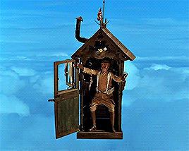 A Statue Of A Woman In A Birdhouse Flying Through The Air GIF